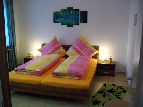 策勒Dogge, Ferienwohnung的一间卧室配有带粉色和黄色枕头的床