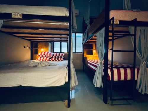 马德望Por Chey Hostel的一间卧室设有两张双层床和一张带枕头的床。