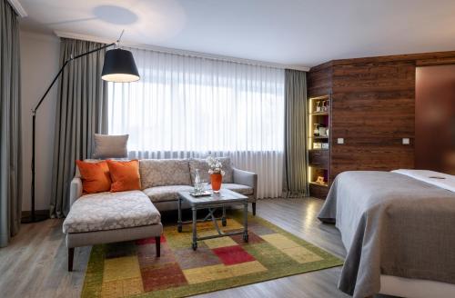 奥伯斯特多夫Hotel Franks的一间卧室配有一张床、一张沙发和一张桌子
