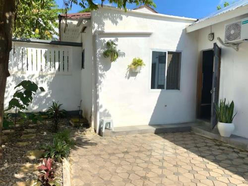 达累斯萨拉姆Kivulini House - close to the beach的白色的房子,设有门和庭院