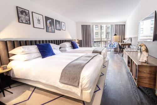 阿姆斯特丹阿姆斯特丹姆金普顿德威特酒店的一间大卧室,配有两张床和一张书桌