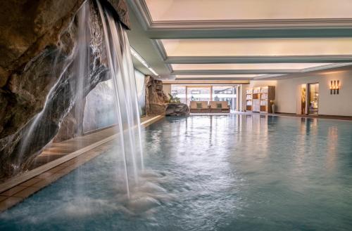 奥伯斯特多夫Hotel Franks的一座位于酒店客房的带瀑布的游泳池