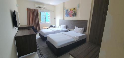 金沙萨Hotel Belle Vie的酒店客房设有两张床和电视。