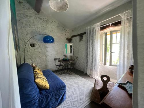Ganacla maison d'Anna chambres d hôtes的客厅设有蓝色的沙发和窗户。