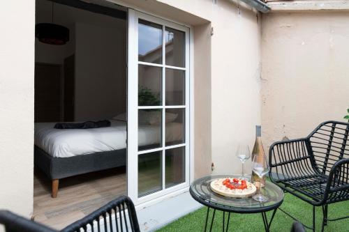 圣特罗佩Villa Sibille - Plein centre de Saint-Tropez的天井配有桌椅和1张床