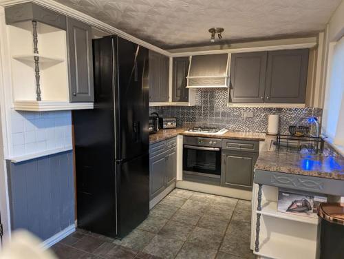 利Home away from home的厨房配有黑色冰箱和灰色橱柜。