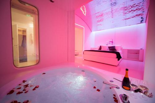 菲登扎戴鲁纳汽车旅馆的带浴缸、床和粉红色照明的客房