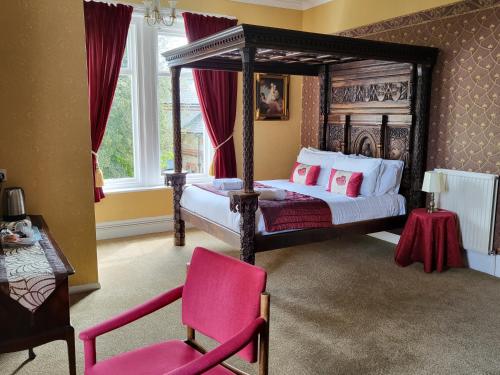 尚克林东山大厅酒店的一间卧室配有天蓬床和粉红色的椅子