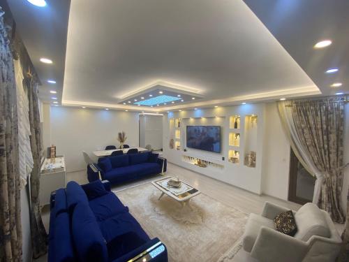 PelitliLüx daire的客厅配有蓝色的沙发和电视
