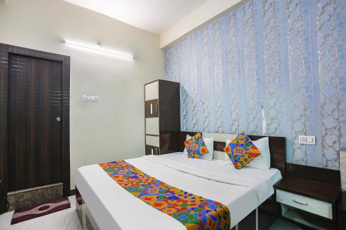 阿拉哈巴德FabHotel Royal Stay Inn的一间卧室设有一张床和蓝色的墙壁