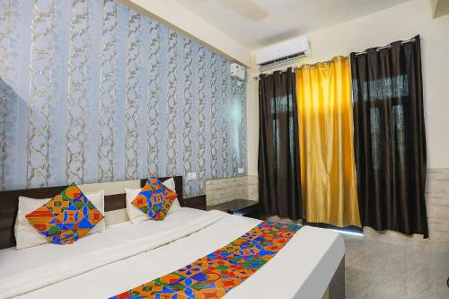 阿拉哈巴德FabHotel Royal Stay Inn的一间卧室设有两张床和一个带窗帘的窗户。