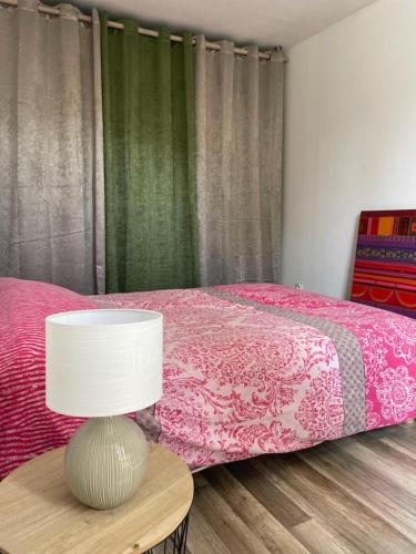 索米尔Maison Saumur的一间卧室配有一张床和一张带台灯的桌子