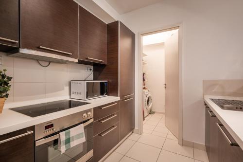 布达佩斯Paulay Private Apartment的厨房配有棕色橱柜和微波炉