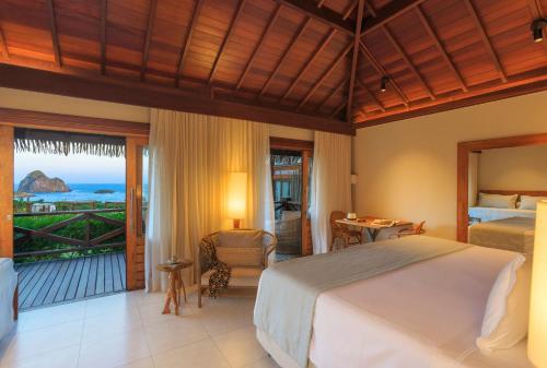 费尔南多 - 迪诺罗尼亚NANNAI Noronha Solar Dos Ventos的一间卧室配有一张床,享有海景