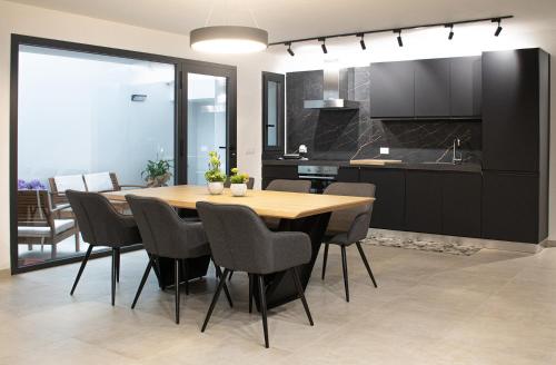 特拉帕尼Domus Alba Apartment的厨房以及带木桌和椅子的用餐室。