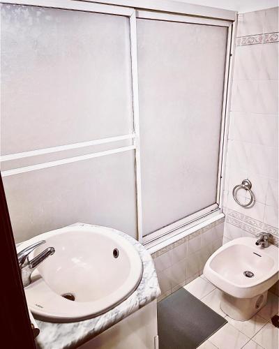 里斯本Residencial First One的带淋浴和盥洗盆的白色浴室