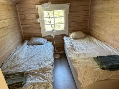 奥克什贝里亚House in Akersberga Stockholm Beach and Sea的木间设有两张床,设有窗户