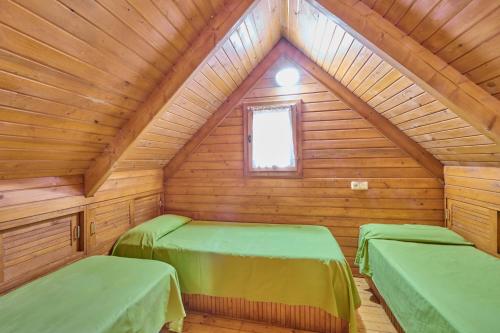 Castellar del Riu富特瑞达露营地的小木屋内带两张床的房间