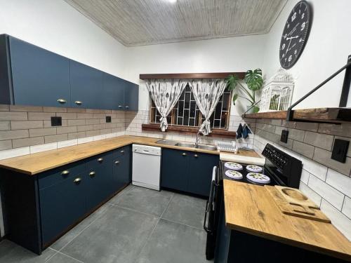 斯瓦科普蒙德Seaview Family Cottage的厨房配有蓝色橱柜和木制台面