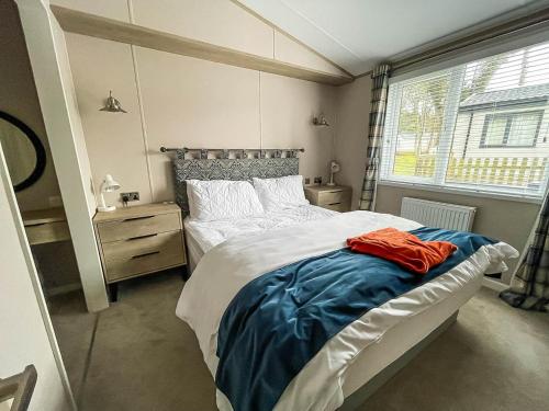 洛斯托夫特Beautiful Lodge With Decking At Azure Seas In Suffolk, Sleeps 6 Ref 32217og的一间卧室设有一张大床和一个窗户。