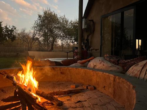 LephalaleSimba Safaris African Pride Exotic Lodge的火坑,周围是两个人躺在枕头上