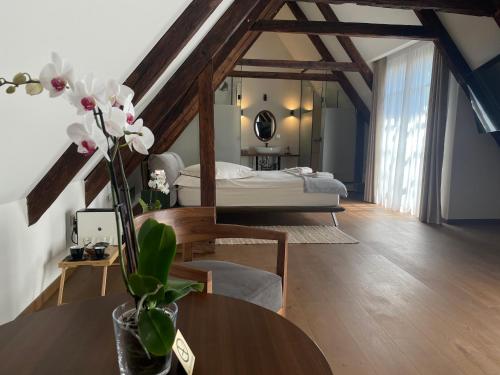 布拉索夫Casa Albert Boutique & Restaurant的一间卧室配有一张床和一张鲜花桌