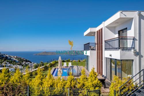 博德鲁姆Farilya Villas by Important Group Travel的白色的建筑,设有游泳池和海洋