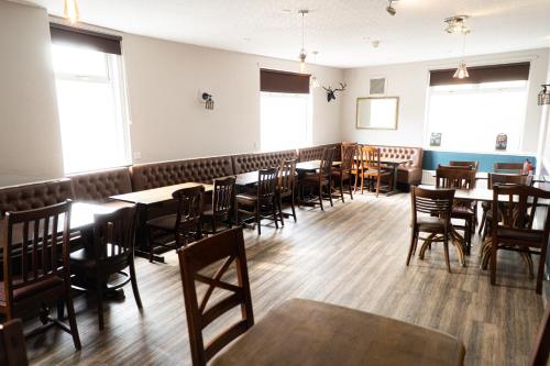 安布尔Masons Arms Amble的用餐室配有木桌和椅子