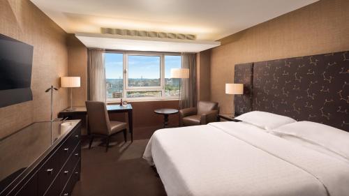 里斯本喜来登葡京酒店和水疗中心的配有一张床、一张书桌和一扇窗户的酒店客房