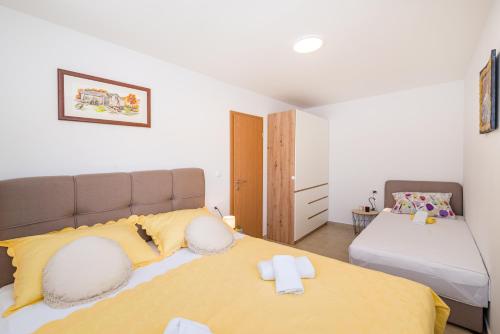 诺维格勒达尔马提亚Holiday home Figurica的一间卧室配有一张带两个枕头的大型黄色床