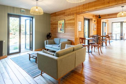CazaubonHuttopia Lac de l'Uby - Gers的客厅配有沙发、椅子和桌子