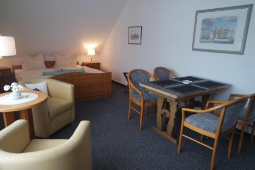 沙普罗德Aparthotel Schafshorn的酒店客房带一张床、一张桌子和椅子
