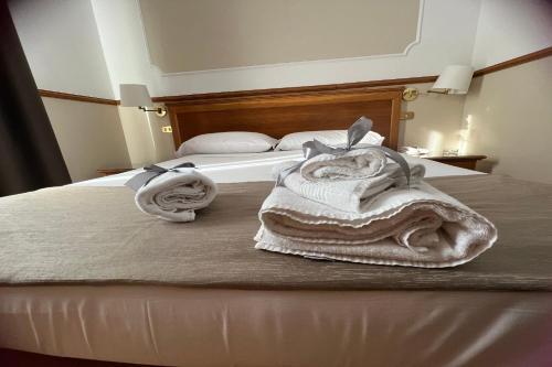 那不勒斯莱奥帕尔迪酒店的一间卧室配有带毛巾的床