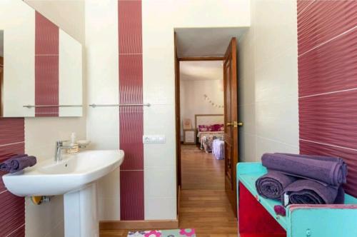 坎佩略CMLove Purple Room的一间带水槽和镜子的浴室以及走廊
