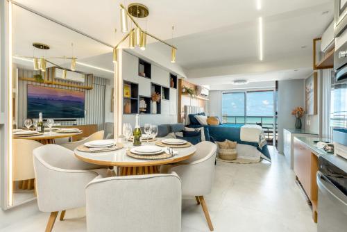 纳塔尔DELUX PRAIA Flats的用餐室以及带桌椅的起居室。