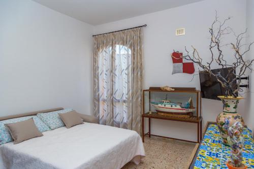 夏卡Matisé Home Relax的一间卧室配有床、桌子和花瓶