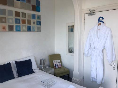 伊斯特布恩Seaview Sanctuary的卧室配有挂在门上的白色长袍