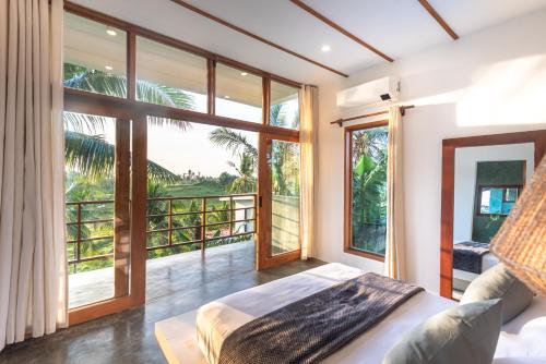 卢纳将军城Tanaw Villas的一间卧室设有一张床和一个大窗户