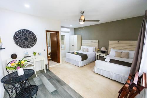 奥尔沃克斯岛Hotel Siesta Holbox的酒店客房配有两张床和一张书桌
