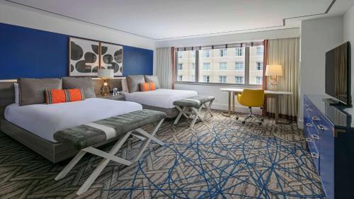 华盛顿The Royal Sonesta Washington DC Dupont Circle的一间酒店客房,设有两张床和电视