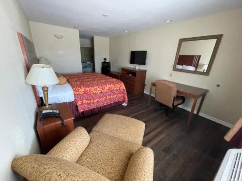 RivieraRiviera Inn and Suites的酒店客房配有床、沙发和桌子。