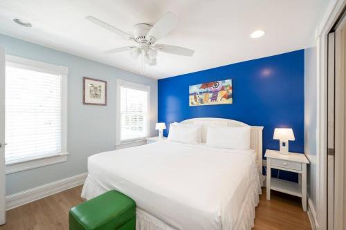 基韦斯特Just steps to Duval- Sleeps 10- Heated Pool House的蓝色的卧室配有白色的床和吊扇