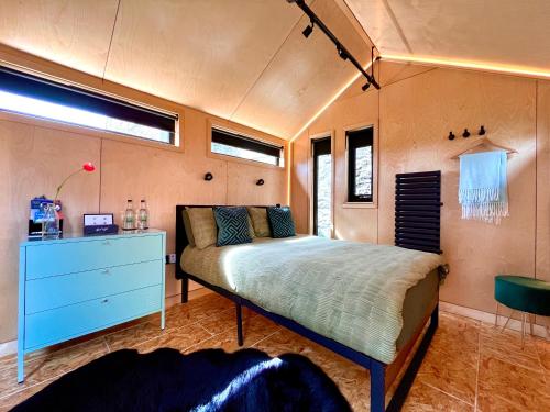 门蒂斯港Trossachs Barn & Cabin的一间卧室配有一张床和一个蓝色梳妆台