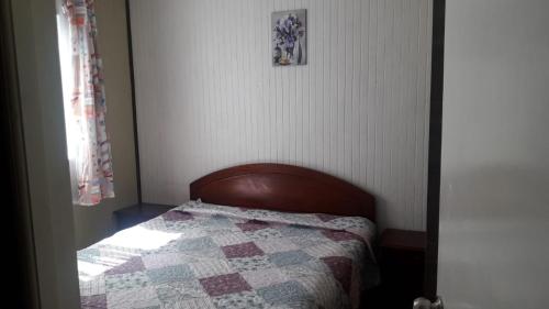 蒙特港Hostal tepual puerto montt的小卧室配有床和被子