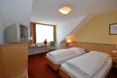 萨尔茨堡科尔彼得酒店的酒店客房设有两张床和电视。