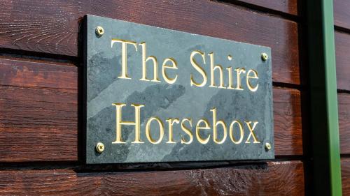 LlanfyllinThe Shire Luxury Converted Horse Lorry with private hot tub Cyfie Farm的木墙上的一个标语,上面写着郡马箱