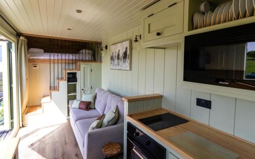 LlanfyllinThe Shire Luxury Converted Horse Lorry with private hot tub Cyfie Farm的一间客厅和厨房,位于一个小房子里