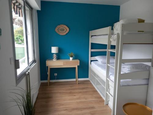 阿卡雄Appt calme au centre du Moulleau的一间卧室设有两张双层床和一张桌子