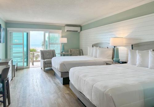 圣徒皮特海滩Thunderbird Beach Resort的酒店客房设有两张床和一个阳台。
