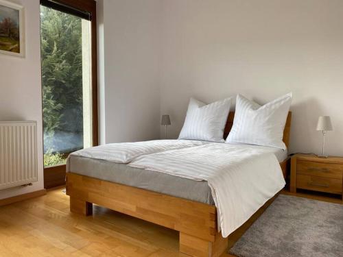 SólySzent Kard Vendégház的一间卧室配有一张带白色床单的床和一扇窗户。